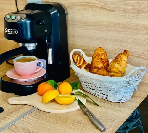 a basket of pastries and a cup of coffee and oranges at Story Cabin Lake in Cîmpeneşti