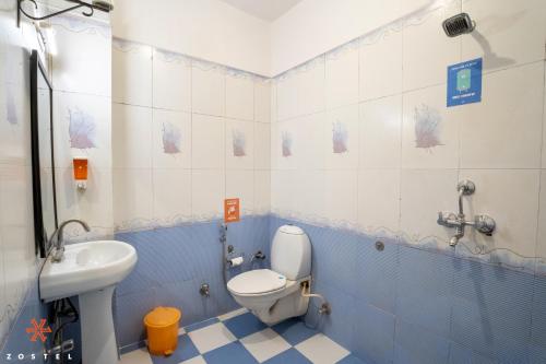 a blue and white bathroom with a toilet and a sink at Zostel Udaipur in Udaipur