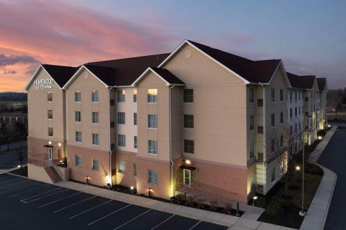 an apartment building with a sunset in the background at Homewood Suites by Hilton York in York
