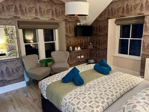 a bedroom with a bed with blue pillows on it at Summerhill Guest House in Betws-y-coed