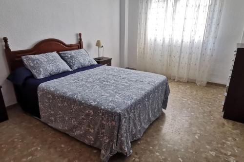 1 dormitorio con 1 cama con edredón azul en Apartamento en la Cala del Moral, en Cala del Moral
