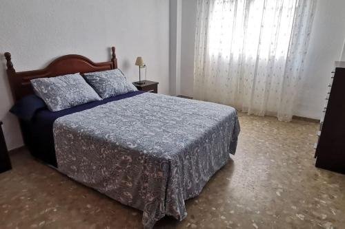 a bedroom with a bed with a blue comforter at Apartamento en la Cala del Moral in Cala del Moral