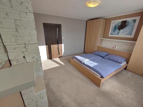 a bedroom with a bed and a stone wall at Privat Apartment Zdenko in Ostrava