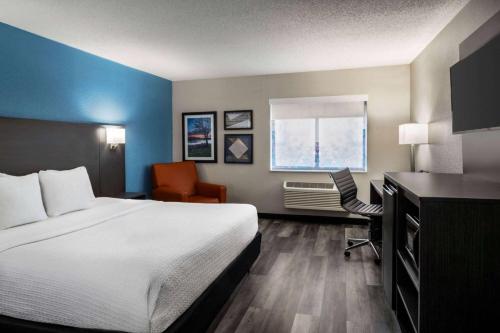 a hotel room with a bed and a desk and a window at La Quinta by Wyndham Chicago Tinley Park in Tinley Park