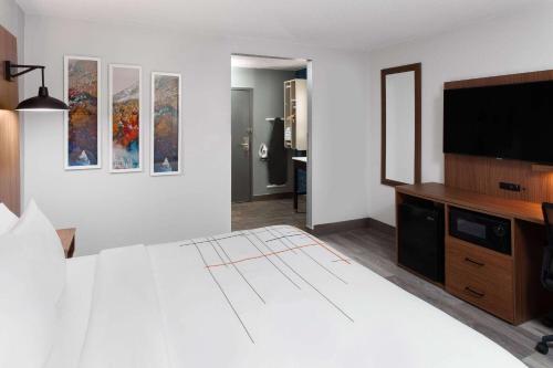 a bedroom with a large bed and a flat screen tv at La Quinta Inn by Wyndham Wausau in Wausau