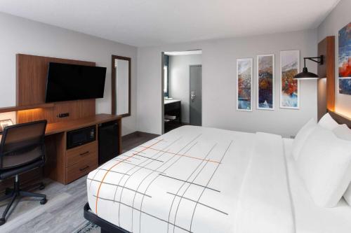 a bedroom with a bed and a desk with a television at La Quinta Inn by Wyndham Wausau in Wausau