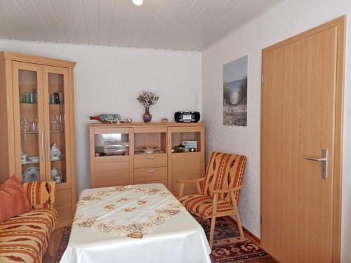a room with a bed and a table and a cabinet at Ferienwohnung Haus Waldesrand in Norderney