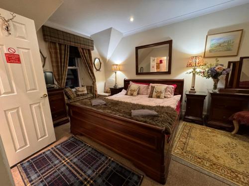 a bedroom with a large bed and a mirror at West Highland Way Hotel in Glasgow