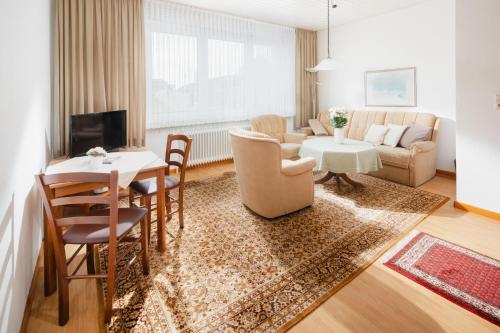 ein Wohnzimmer mit Tisch und Stühlen und einer Couch in der Unterkunft Haus Meeresblick in Norderney