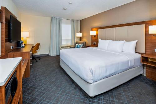 a hotel room with a large bed and a television at Comfort Inn & Suites in Ingersoll