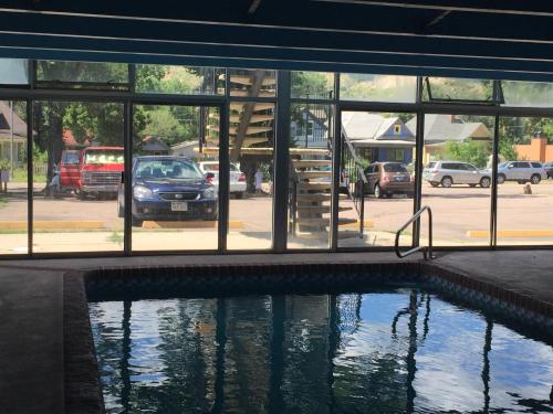 a swimming pool in front of a building with windows at Garden of the Gods Motel in Colorado Springs