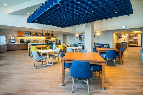 Ingersollにあるコンフォート イン アンド スイーツ インガーソルのテーブルと椅子のあるレストラン、カフェテリア