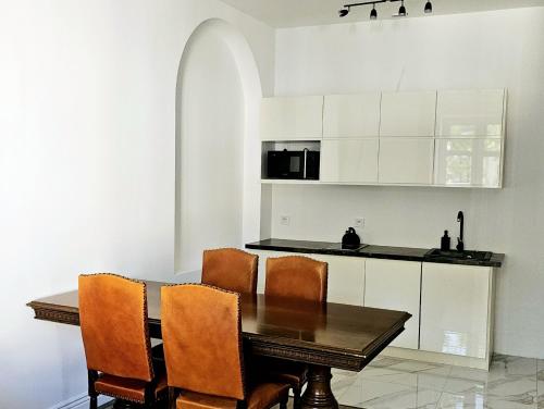 a kitchen with a wooden table and chairs at Pawia Apartments Centrum in Krakow