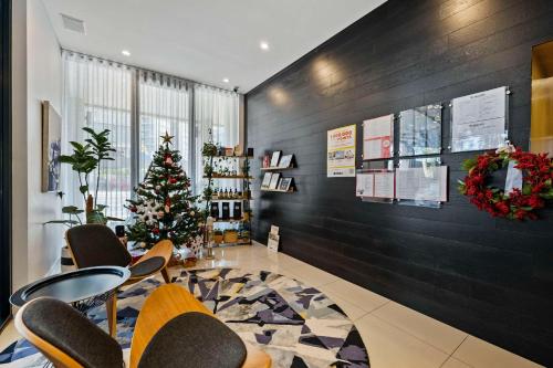 uma sala de espera com uma árvore de Natal e cadeiras em The Kingsford Brisbane Airport, Ascend Hotel Collection em Brisbane