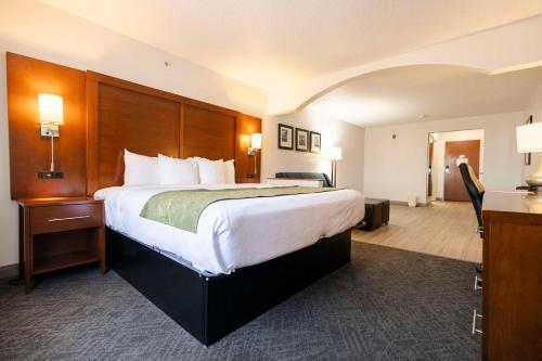 Habitación de hotel con cama grande y escritorio. en Comfort Suites Springfield, en Springfield