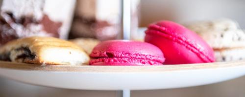 a plate of pink cookies and donuts on a plate at Mirfa Hotel in Al Marfaʼ