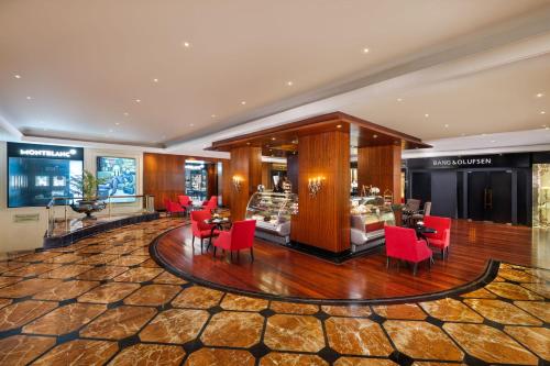a lobby with red chairs and tables in a store at Taj Krishna in Hyderabad