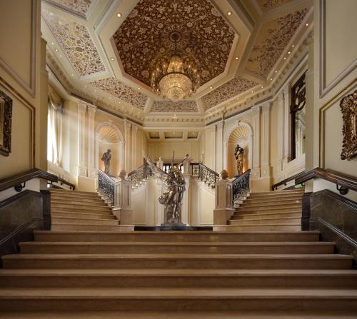 an ornate staircase in a building with a chandelier at Taj Krishna in Hyderabad