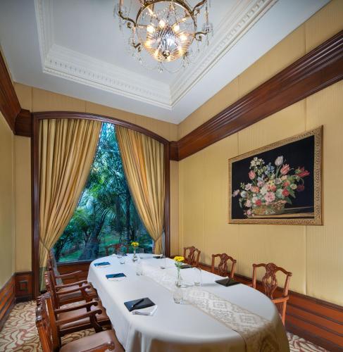 a dining room with a long table and a chandelier at Taj Krishna in Hyderabad