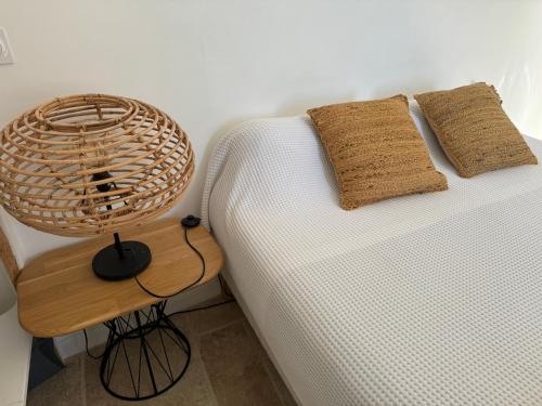 a white couch with two pillows and a table at Studio Liège, vue mer au village de Bormes les Mimosas in Bormes-les-Mimosas