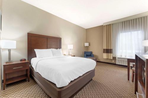 Habitación de hotel con cama grande y escritorio. en Comfort Inn & Suites, en Johnstown