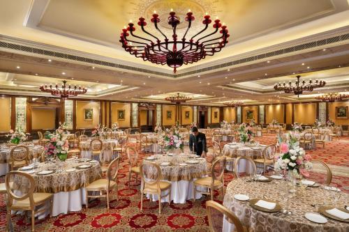 a banquet hall with tables and chairs and a chandelier at Taj Krishna in Hyderabad