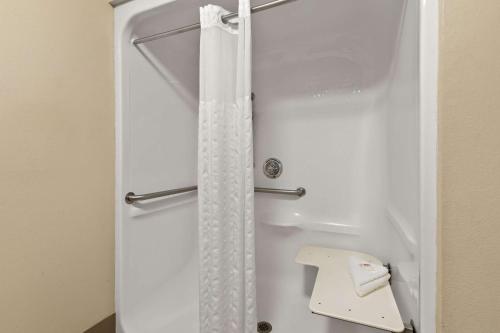 La salle de bains est pourvue d'une douche avec un rideau de douche blanc. dans l'établissement Comfort Suites, à Nashville