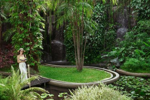 a woman standing in a garden with a waterfall at Taj Krishna in Hyderabad