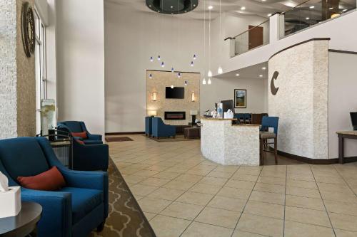 a waiting room with blue chairs and a counter at Comfort Suites in Granbury