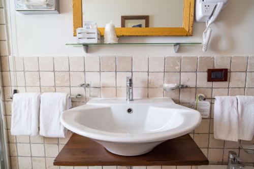 a bathroom with a sink and a mirror and towels at Best Western Hotel Santa Caterina in Acireale