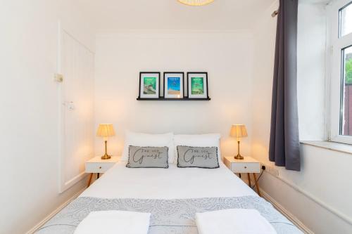 una camera da letto con un letto bianco e due lampade di The TRAIL Special Apartment In Afan Forest Bike Park By StayStaycations a Cymmer