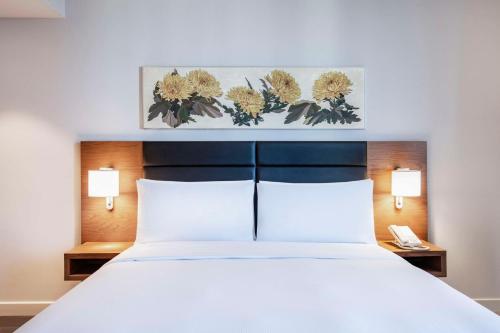 a bedroom with a white bed with two lamps at Hilton Garden Inn Tbilisi Chavchavadze in Tbilisi City