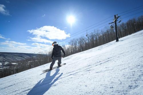 a person riding a snowboard down a snow covered slope at Hotel Canandaigua, Tapestry Collection By Hilton in Canandaigua