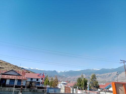 a view of a town with mountains in the background at T.P Homestay in Mechuka