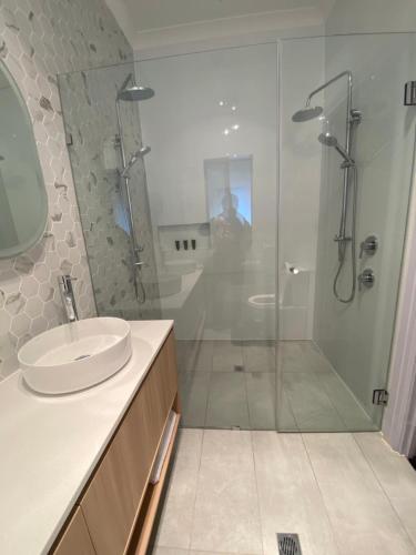 La salle de bains est pourvue d'une douche en verre et d'un lavabo. dans l'établissement Doyles on the Bay, à Kingscote