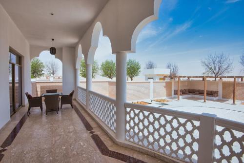 a patio with a table and chairs on a balcony at Liwa Hotel in Mezairaa