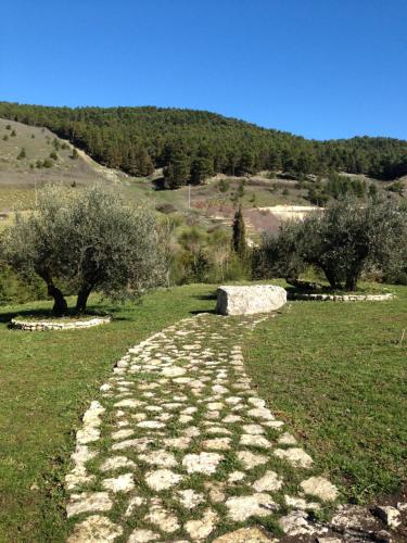 a stone path in a field with trees on a hill at Agriturismo Serra Moneta in Santo Stefano Quisquina