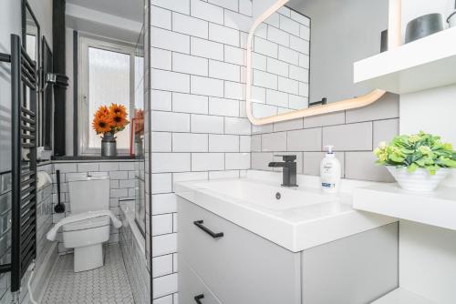 Baño blanco con lavabo y aseo en Pass the Keys Trendy Historic flat sleeps 4 to 6 near Leith Shore, en Edimburgo