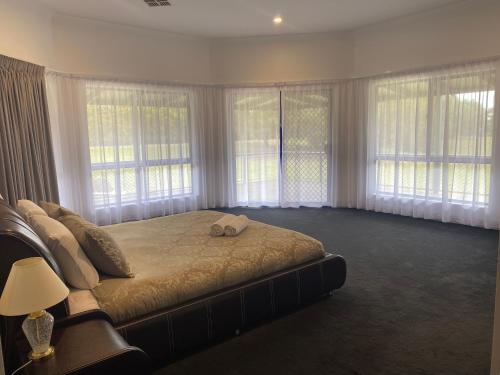 a large bedroom with a large bed with windows at Doyles on the Bay in Kingscote