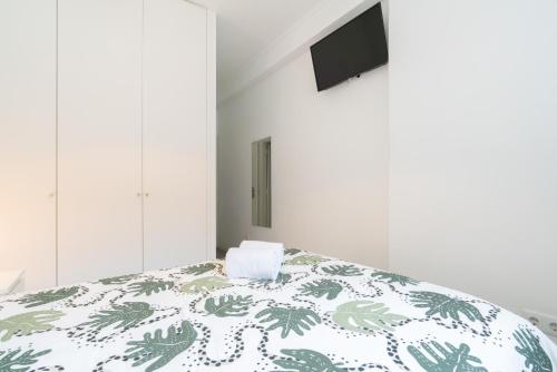1 dormitorio con 1 cama con edredón verde y blanco en Moreira Terrace, en Oporto