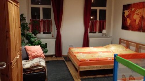 um quarto com uma cama, uma cadeira e janelas em Ferienwohnung Paschke Chemnitz Schönau em Chemnitz