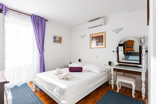 a bedroom with a bed and a desk and a mirror at Villa Amigo in Podstrana