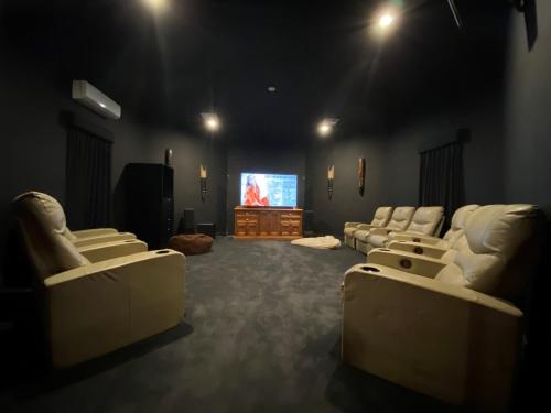 a living room with white couches and a tv at Doyles on the Bay in Kingscote