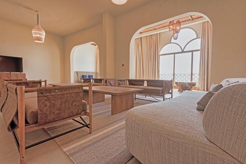a bedroom with a bed and a living room at Liwa Hotel in Mezairaa