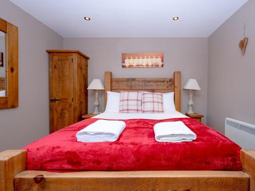 a bedroom with a large bed with a red blanket at Pass the Keys Tranquil Hideaway in Wells, Somerset - One Bedroom Cottage in Wells