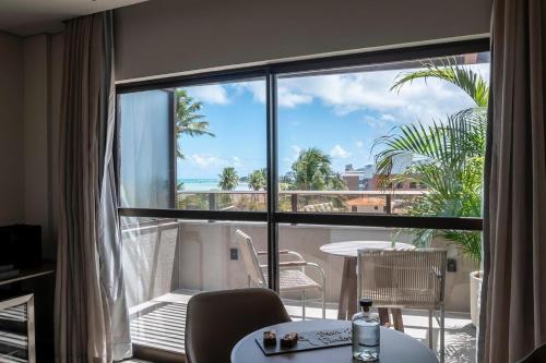 a room with a balcony with a view of the ocean at HCM - Hotel Corais de Manaira in João Pessoa