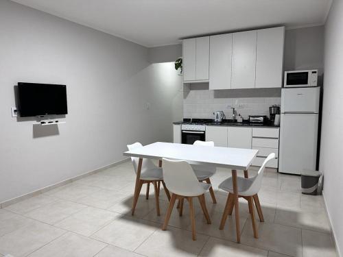 cocina blanca con mesa blanca y sillas en Riffel 3 en Aldea Camarero
