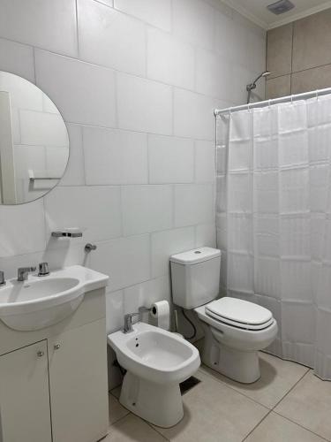 a white bathroom with a toilet and a sink at Riffel 3 in Libertador San Martín