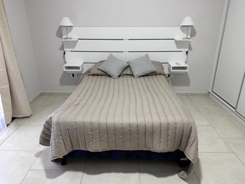 1 dormitorio con 1 cama grande y 2 almohadas en Riffel 3 en Aldea Camarero