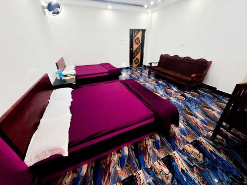 1 dormitorio con 1 cama grande de color púrpura y 1 sofá en Parinay Vatika Inn, en Deoghar